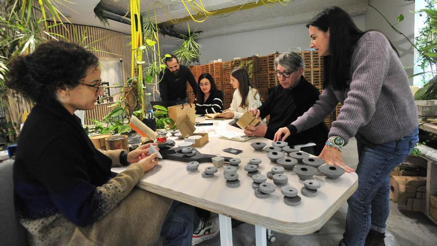 Antonio Maciá, con su equipo, en las instalaciones de su estudio, World of Holistic Architecture (Woha), con los envases del perfume.