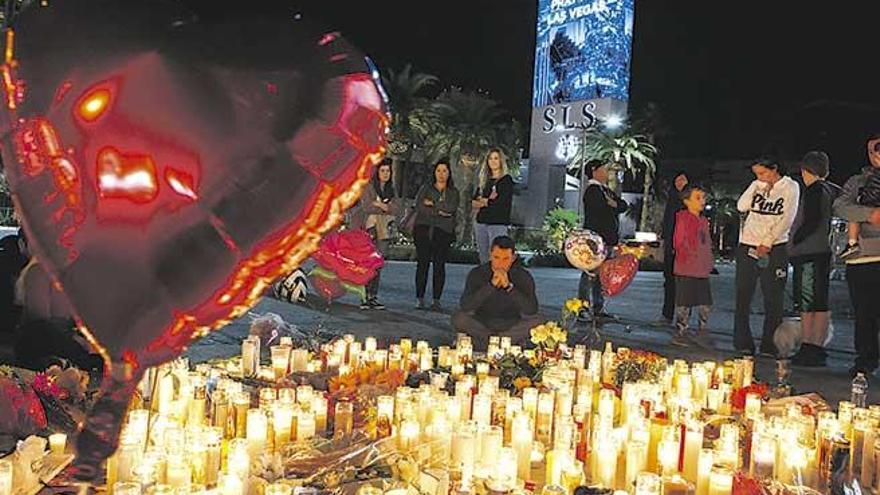 Un grupo de personas se detiene ante un altar improvisado en memoria de lsa víctimsa del tiroteo.