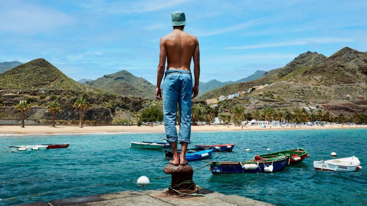 Foto de promoción turística de un joven en la playa de Las Teresitas.