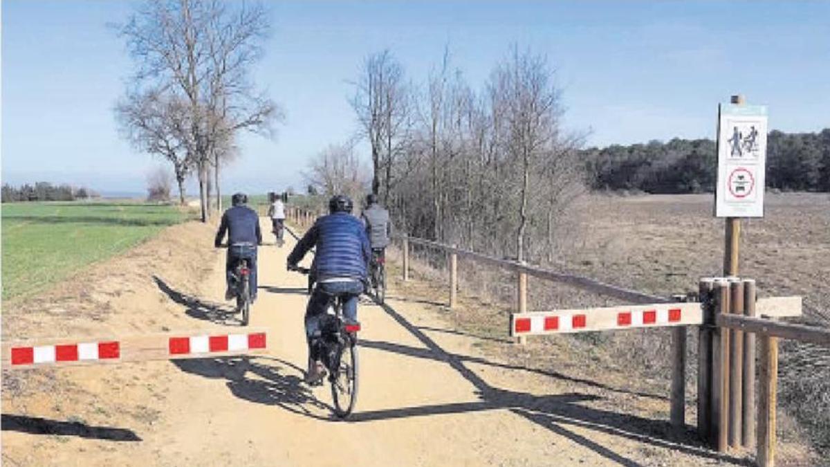 Unos ciclistas pedalean por un tramo de la ruta del Tren Pinxo.