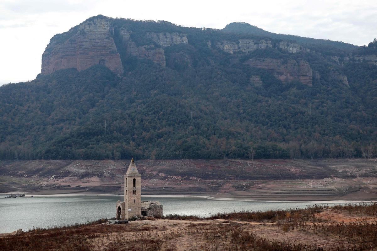 Esta fotografía tomada el 15 de enero de 2024 muestra la iglesia de Sant Roma de Sau en la orilla del estiaje del embalse de Sau, situado en la provincia de Girona en Cataluña. Cataluña lucha contra una sequía histórica desde hace tres años y algunos residentes ya experimentan restricciones de agua en su vida diaria.