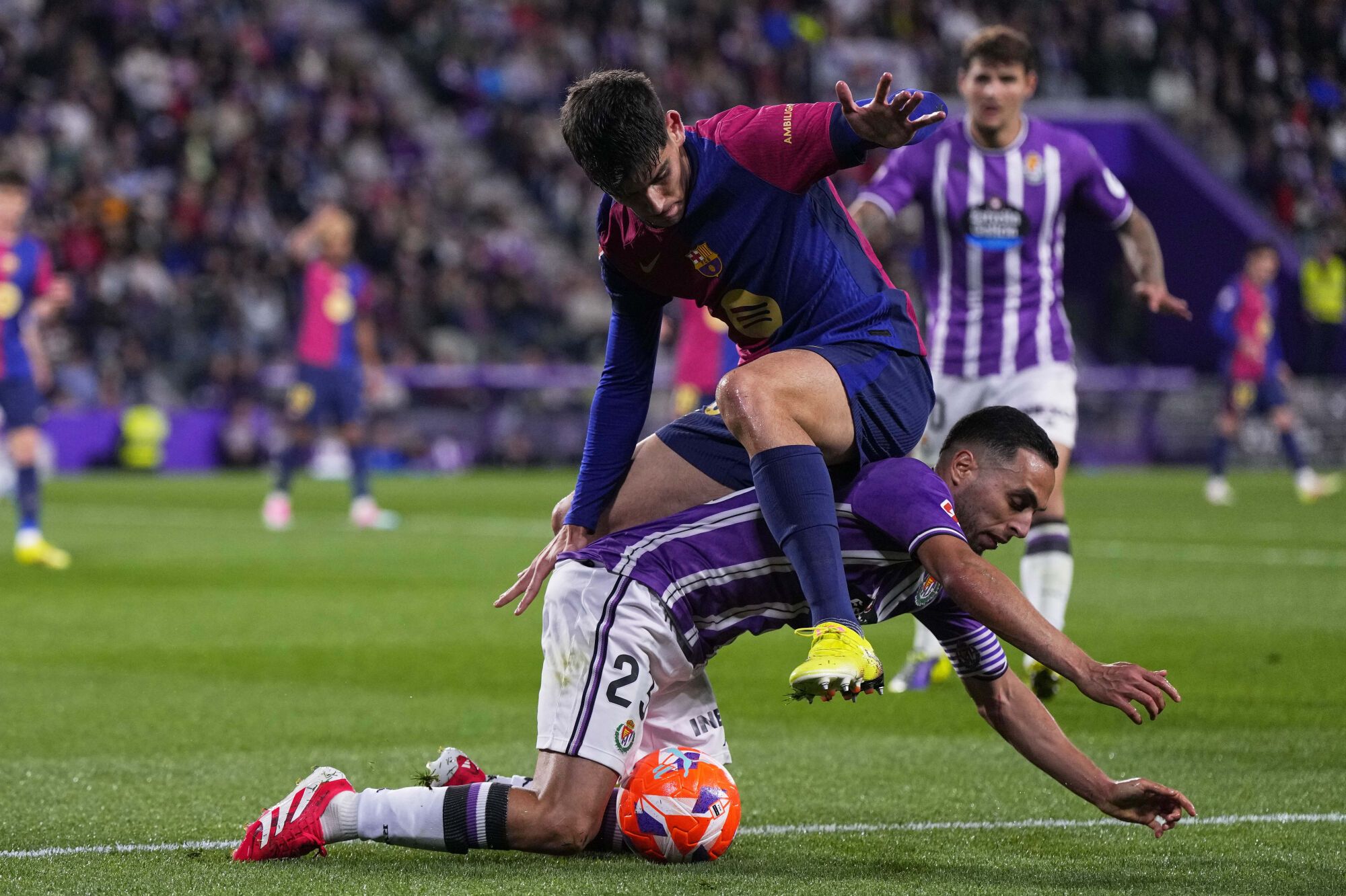 Barcelona's Gerard Martin, top, and Valladolid's Anuar challenge for the ball during the Spanish La Liga soccer match between Valladolid and FC Barcelona at the Jose Zorrilla stadium in Valladolid, Spain, Saturday, May 3, 2025. (AP Photo/Manu Fernandez). EDITORIAL USE ONLY/ONLY ITALY AND SPAIN