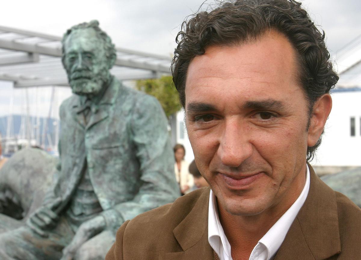 EL ESCULTOR JOSE MOLARES JUNTO A SU OBRA DURANTE EL ACTO DE INAUGURACION DE LA ESTATUA AL ESCRITOR FRANCES JULIO VERNE EN EL MUELLE DE LA MARQUESINA DE VIGO, FRENTE AL EDIFICIO DEPORTIVO DEL REAL CLUB NAUTICO