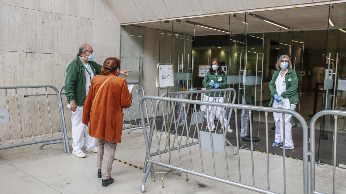 Los sanitarios indican la zona por la que debe acceder a una de las usuarias que acudió ayer al palacio de congresos a vacunarse.