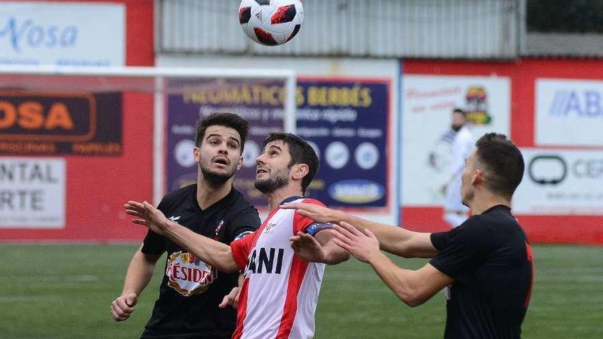 Mauro controla un balón de cabeza ante la oposición de dos rivales. // Gonzalo Núñez