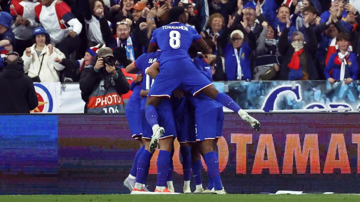 Los jugadores franceses se agolpan sobre Ousmane Dembélé después de que marcara el 2-0.