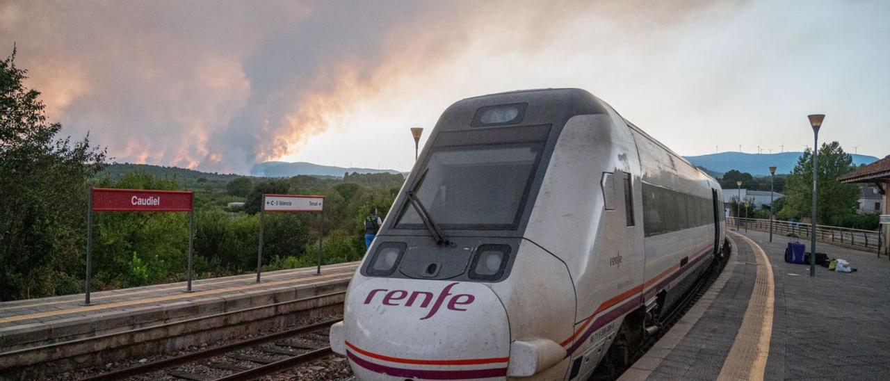 El tren llegado el martes a Caudiel tras el incidente ante las llamas, al fondo.  | ANDREU ESTEBAN