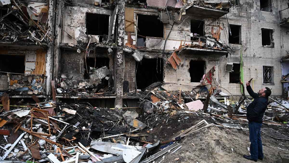 Un hombre toma fotos de un edificio residencial dañado por los ataques rusos, en la calle Koshytsa, en Kiev