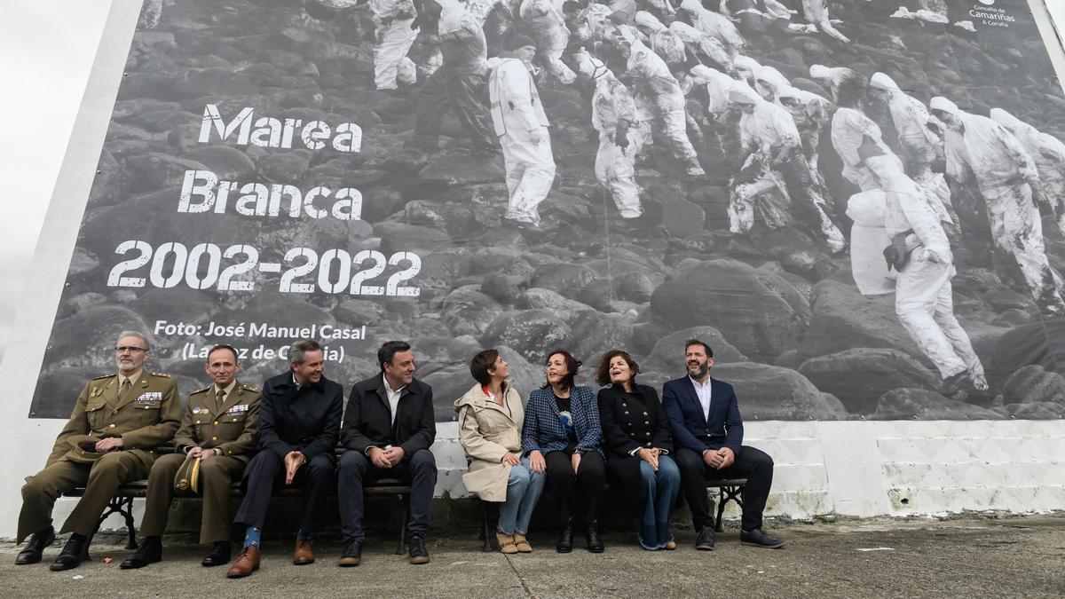 A ministra de Política Territorial,  Isabel Rodríguez (4d), e a alcaldesa de Camariñas, Sandra Insua Rial (3d), pousan baixo un aos voluntarios durante o acto institucional do 20 aniversario da catástrofe do buque Prestige, en Camariñas, A Coruña