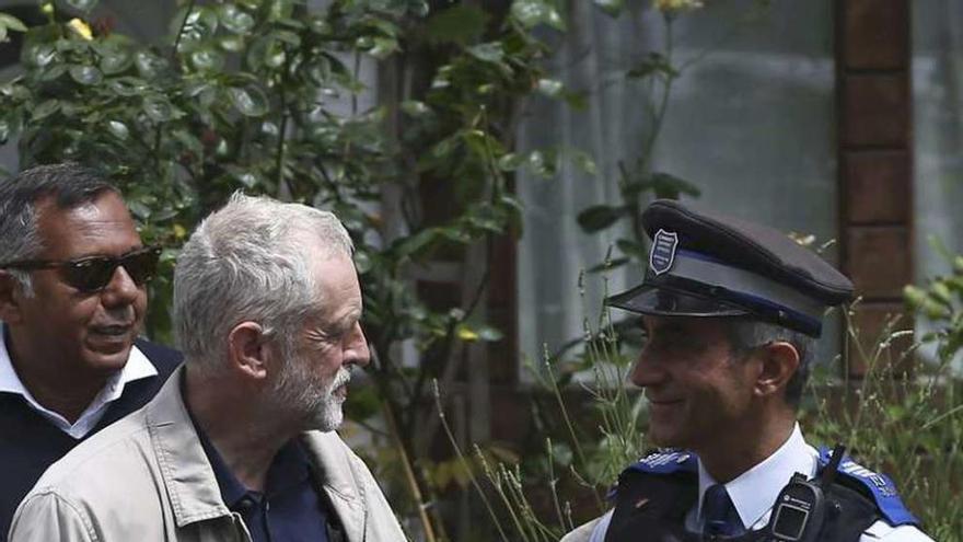 Corbyn, el sábado, hablando con un policía ante su casa. // Reuters