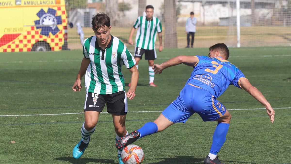 Iván Martínez, jugador del Córdoba B, trata de regatear a un jugador del Cartaya.