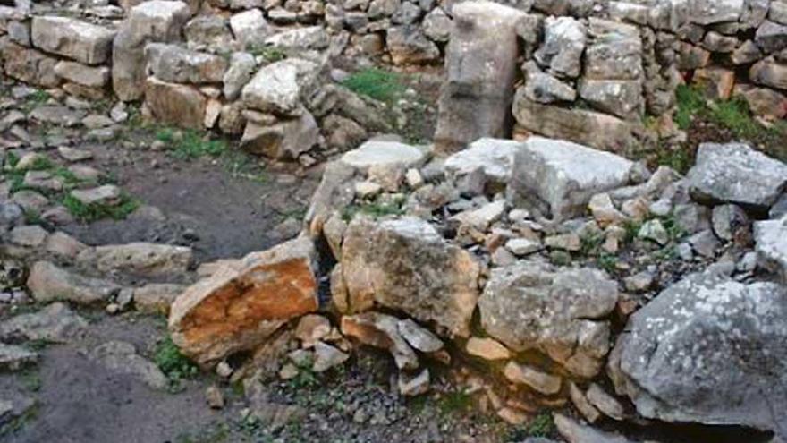 Una gran piedra de un muro ya caído del yacimiento prehistórico denota la necesidad de actuar.