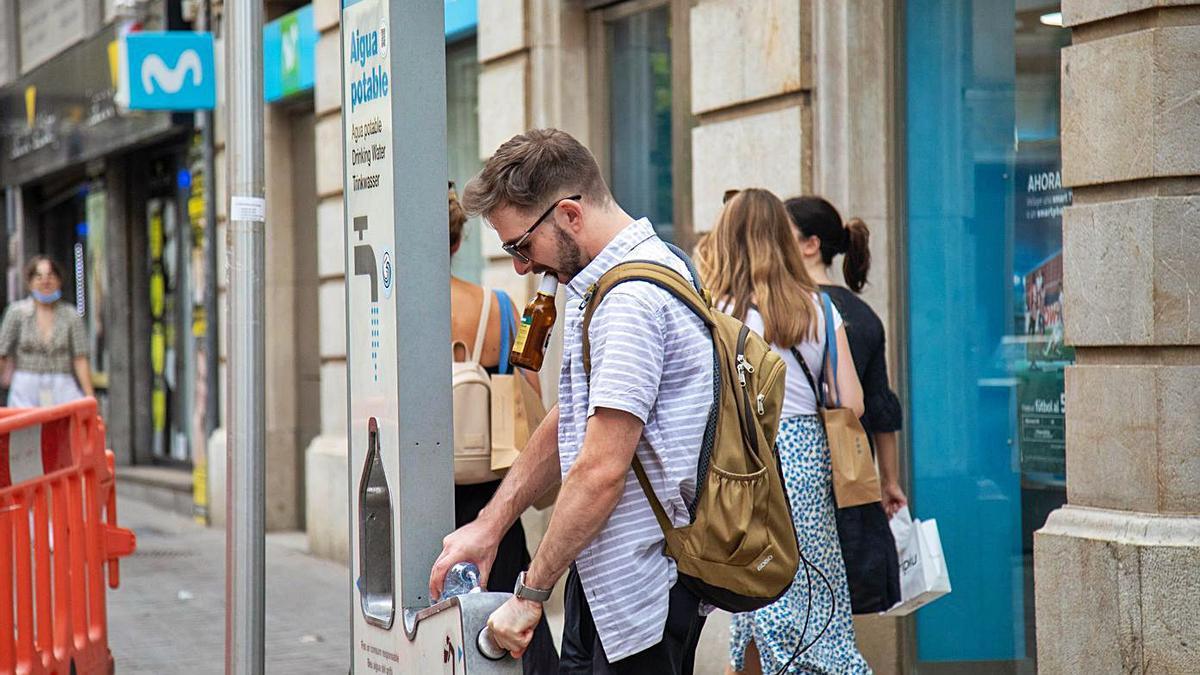 Un hombre se refrescaen Palma en plenaola de calor. |  GUILLEM BOSCH