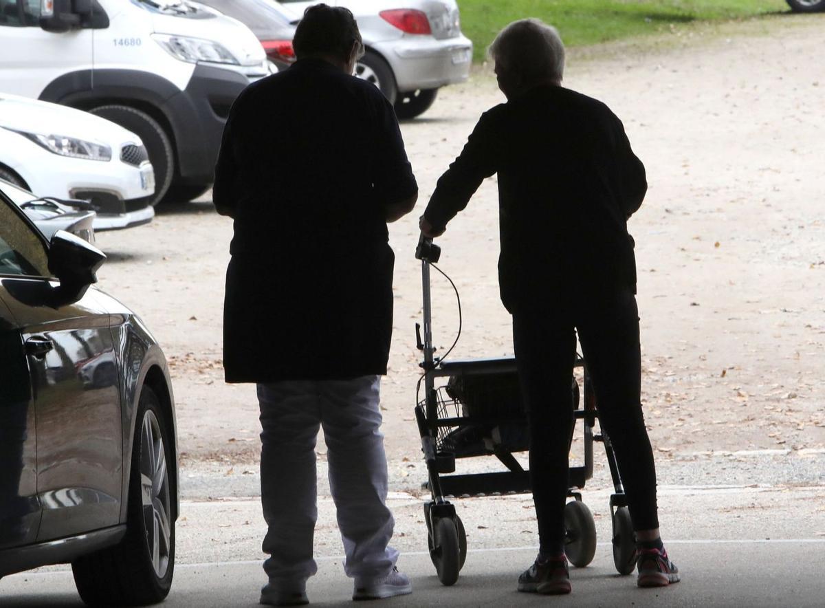 Una trabajadora acompaña a una persona mayor.