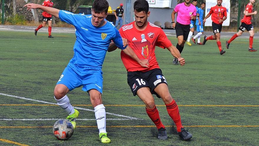 Melo, de la UD Guía, intenta robarle un balón a Rober, zaguero del Atlético Tacoronte, ayer en el Octavio Estévez. | | ARIANNA MOLINA