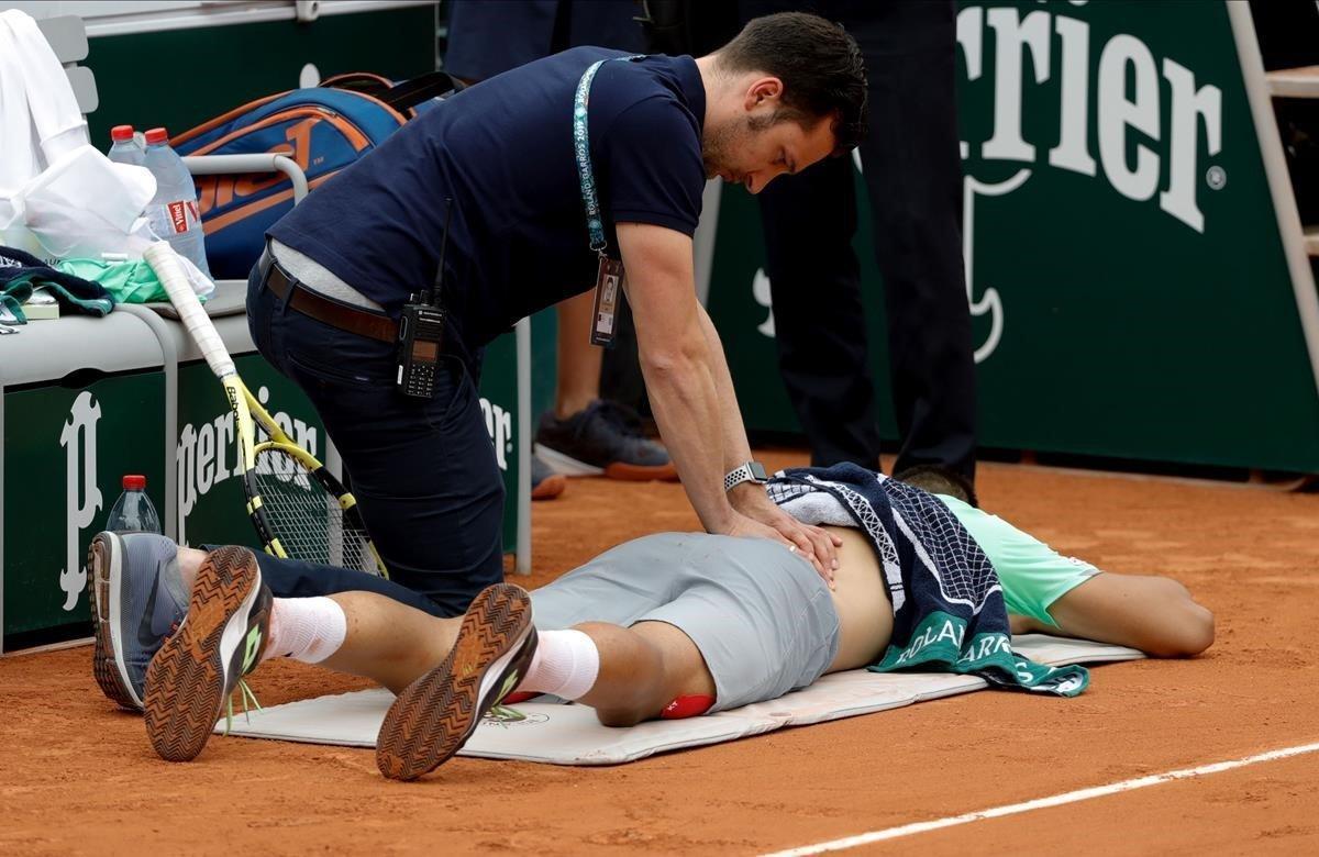 El francés Antoine Hoang es tratado por personal médico durante el partido de la segunda ronda de individuales contra el español Fernando Verdasco, en el quinto día del torneo de tenis Roland Garros 2019.