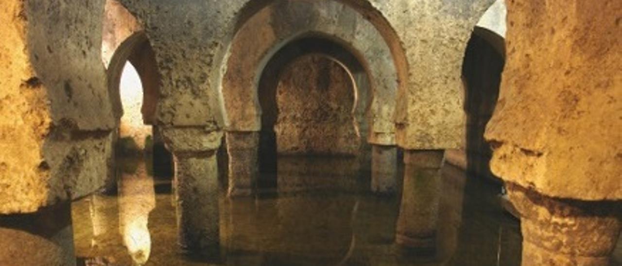 Una imagen del Aljibe de Cáceres. El agua cae a chorros este domingo desde la parte superior.