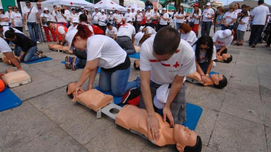 Voluntarios de Cruz Roja y ciudadanos aprenden primeros auxilios, ayer, en la trasera de Santa Catalina. | andrés cruz