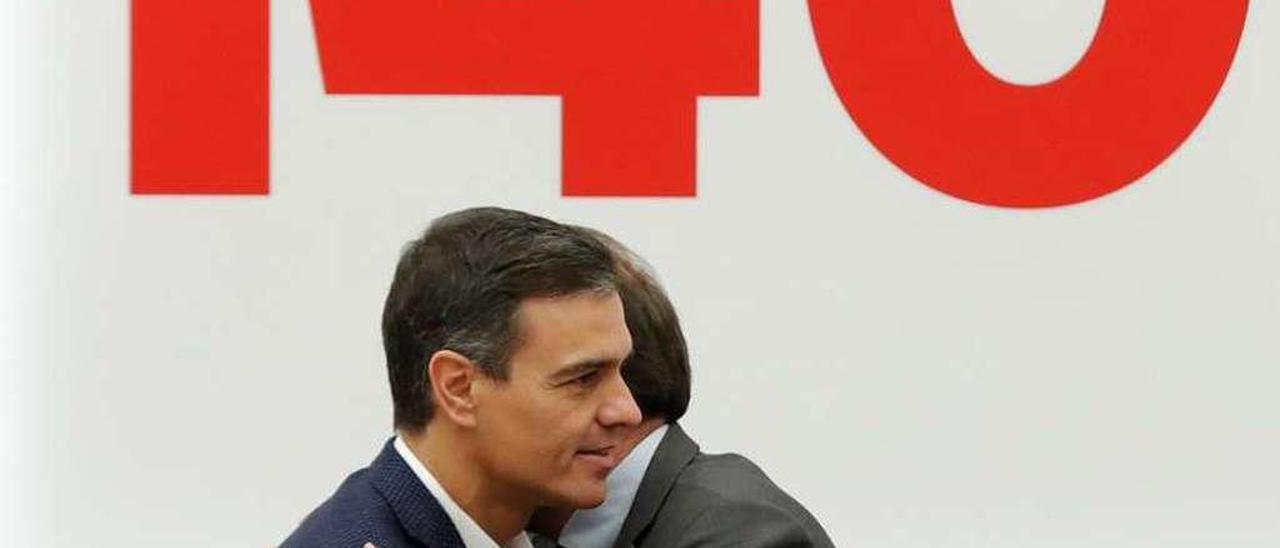Pedro Sánchez abrazándose ayer con el portavoz de la comisión ejecutiva, Óscar Puente, bajo el número que marcaba su sueño en la vuelta a las urnas.