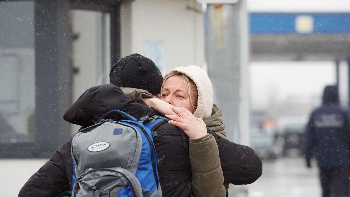 Una pareja se abraza mientras refugiados ucranianos esperan un transporte en el puesto de control de la frontera entre Moldavia y Ucrania.