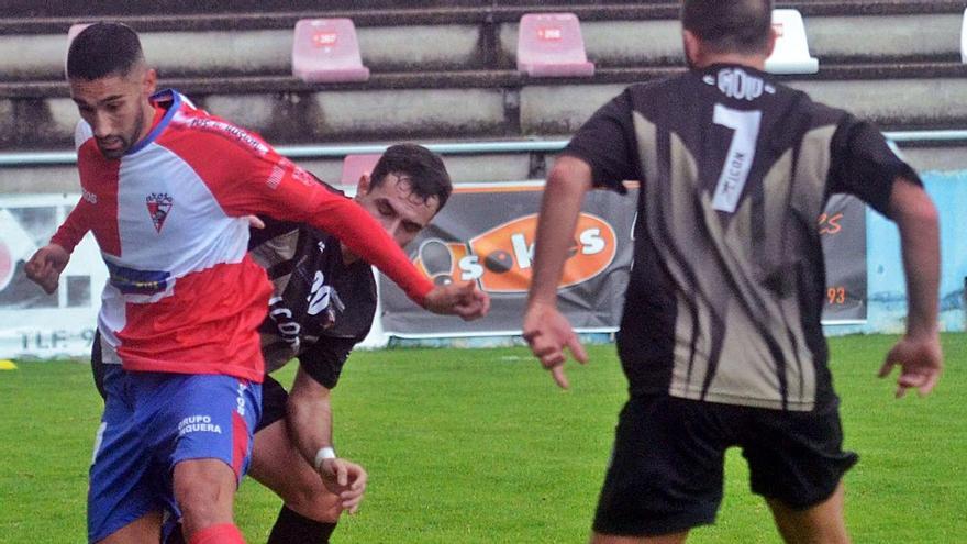 El arlequinado Róber trata de proteger al balón ante dos jugadores del Choco.