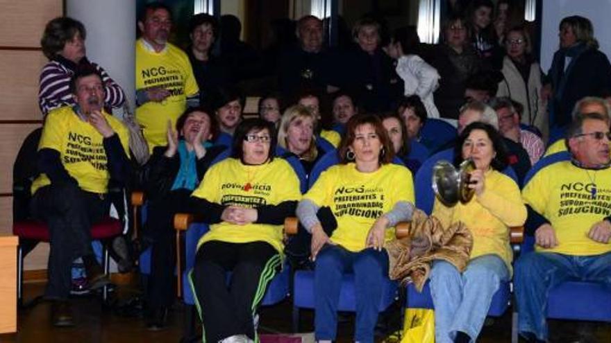 Algunos de los afectados de Moaña por las preferentes y subordinadas protestando ayer en el salón de plenos del Concello.  // Gonzalo N.