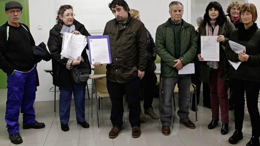 Afectados, ayer en Gijón, posan con las notificaciones de la deuda contraída por sus familiares con el ERA y que ahora les reclaman.