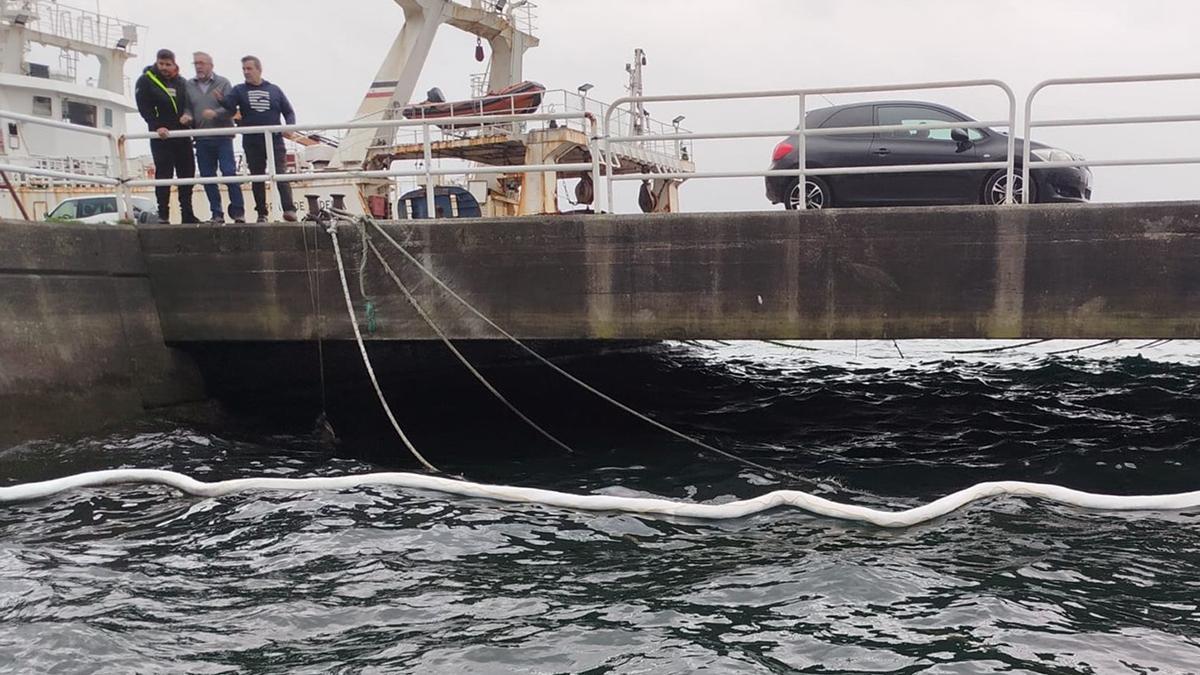 Barrera anticontaminación desplegada en el muelle