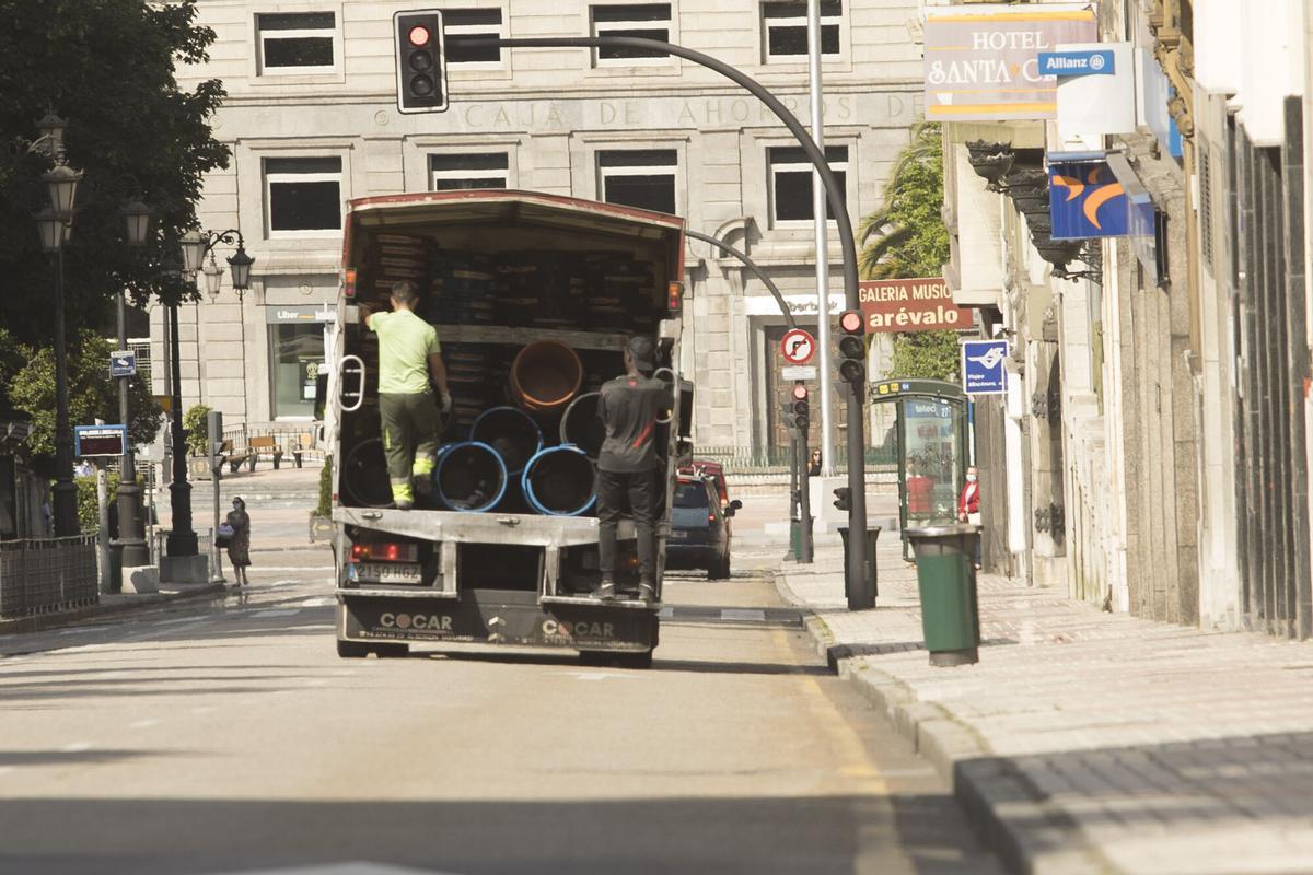 Unos operarios del Ayuntamiento hacen el reparto de cubos de basura.