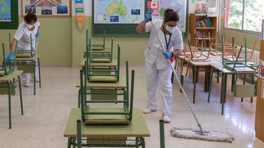 Dos trabajadoras de limpieza desinfectan un aula en Murcia