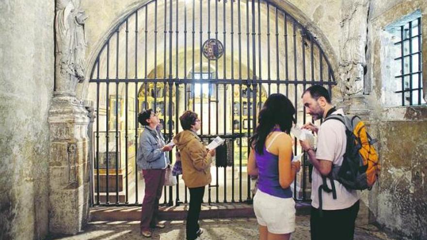 Un grupo de visitantes, en el interior de la Cámara Santa, protegida por una verja.