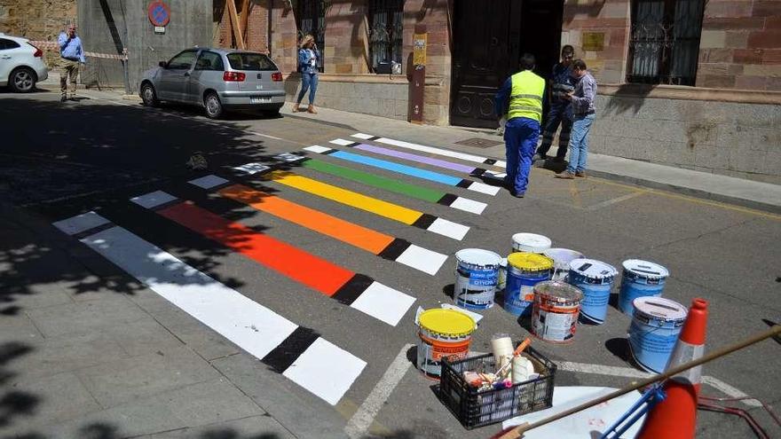 Un operario municipal finalizando las labores de pintura en el paso de peatones.