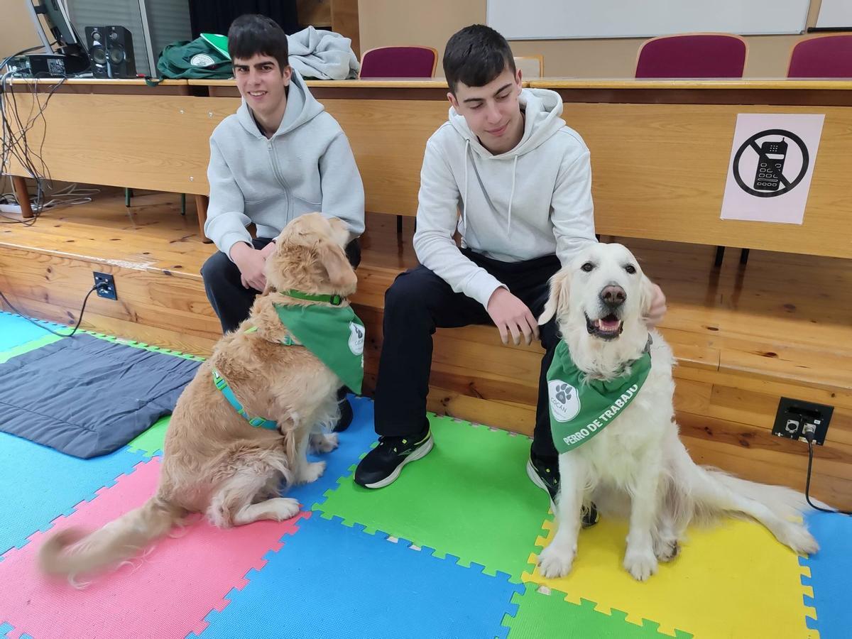 Dos alumnos del IES A Paralia posan con los perros de Cocan.