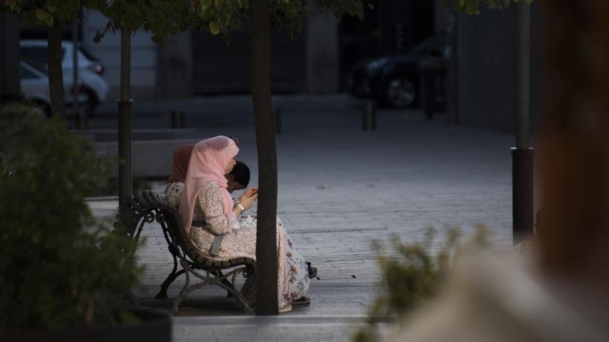 Una ciutadana amb hijab asseguda en un banc de Manresa