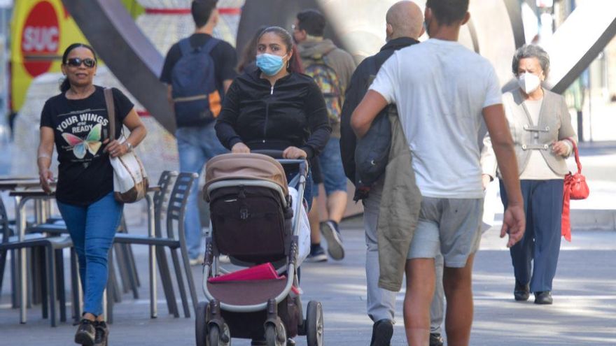 Personas con y sin mascarilla en Triana.