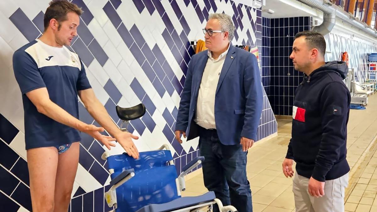 El alcalde con la nueva silla para la piscina