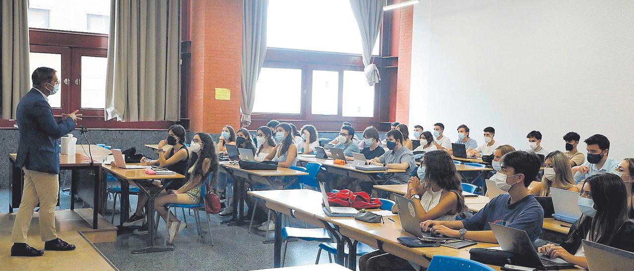 Un profesor imparte clase en un aula de derecho de la UV