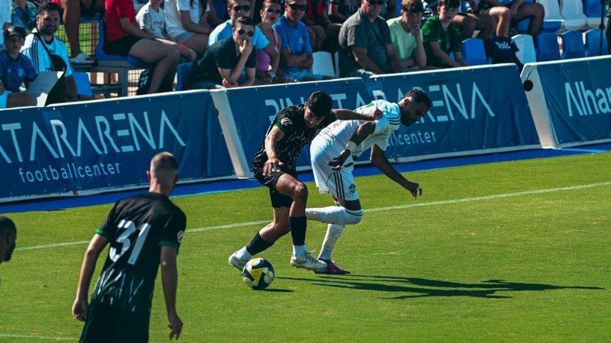 Didac pelea el balón bajo la mirada de Ismael.