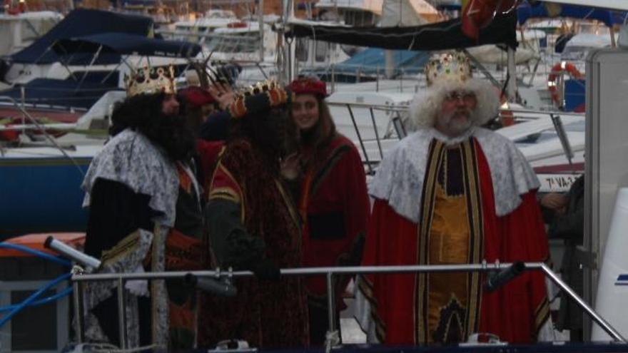 Juan Miguel, con peluca y barbas blancas, junto a Gaspar, Baltasar y los pajes, en el momento de atracar en el puerto deportivo