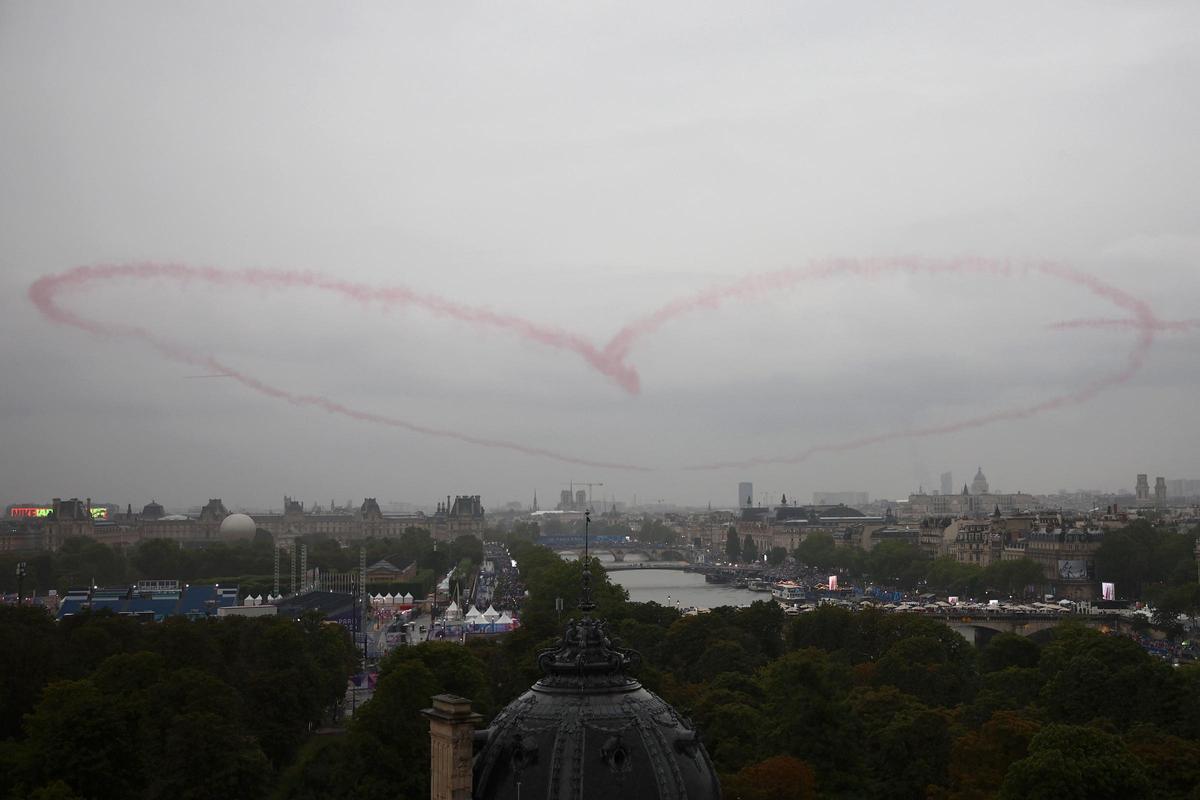 El equipo de acrobacia aérea de élite de la Fuerza Aérea francesa, Patrouille de France, dibuja un corazón en el cielo mientras sobrevuela el río Sena durante la ceremonia de apertura de los Juegos Olímpicos de París 2024