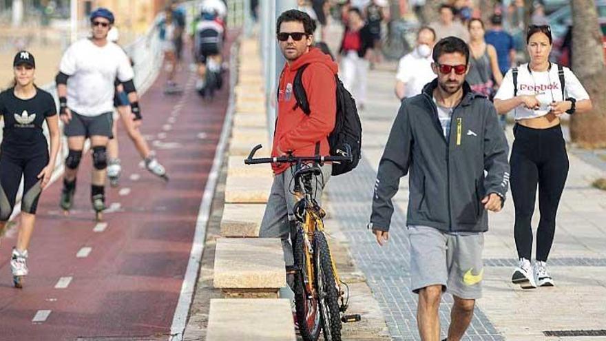 Ciudadanos paseando ante la playa de Can Pere Antoni, en Palma.