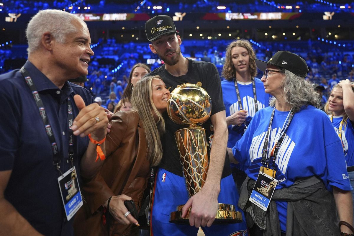 Oklahoma City Thunder forward Chet Holmgren, center, holds the Larry OBrien Championship Trophy as he celebrates with his team after winning the NBA basketball championship with a Game 7 victory against the Indiana Pacers Sunday, June 22, 2025, in Oklahoma City. (AP Photo/Julio Cortez)
