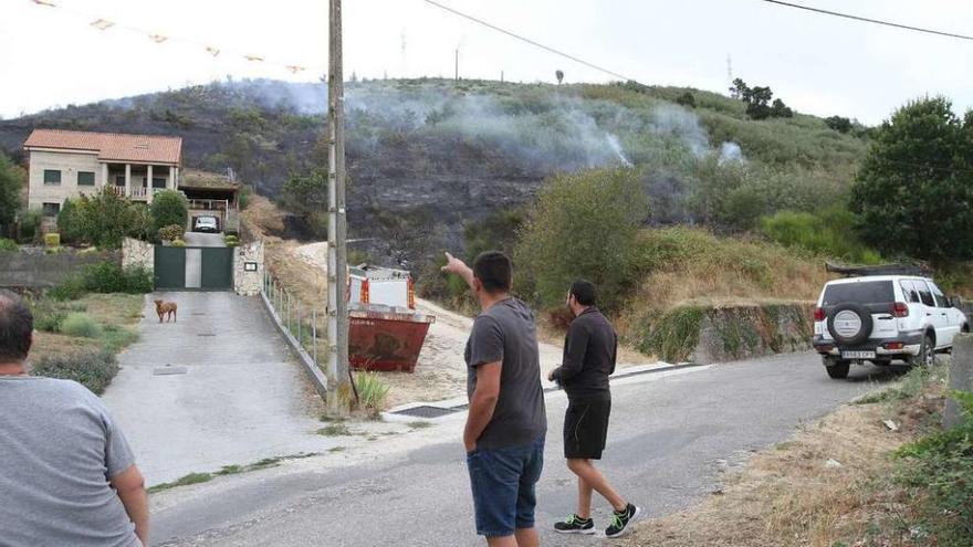 Vecinos de Velle señalan la zona quemada próxima a las casas. // Iñaki Osorio