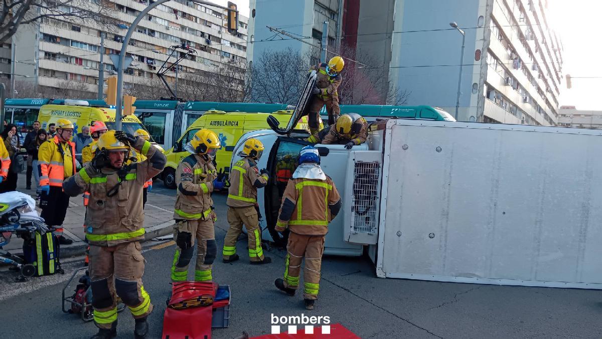 Los Bombers de la Generalitat trabajando para excarcelar al conductor de un camión tras un choque con un tranvía en Sant Adrià de Besòs