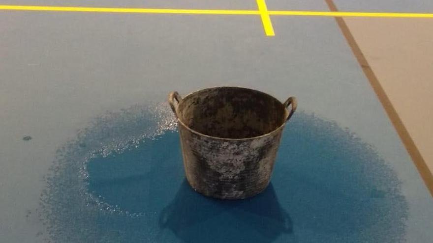 Una galleda a la pista del pavelló per les goteres.