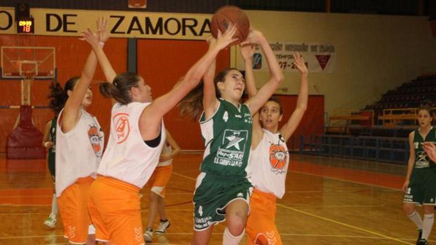 Una jugadora del Repostar lanza a canasta rodeada de defensoras del Caja Rural Zamarat.