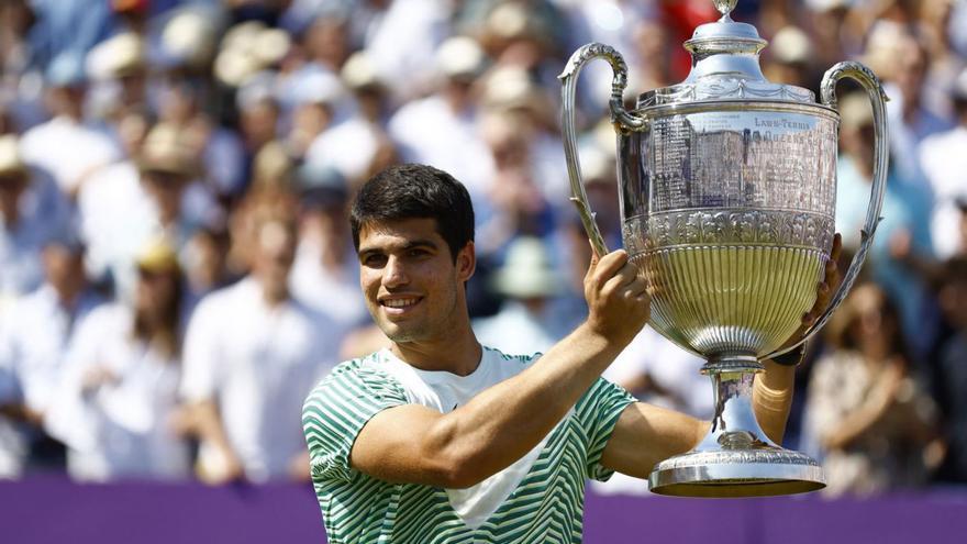 Carlos Alcaraz levanta el trofeo conquistado en Queen’s. | PETER CZIBORRA/REUTERS