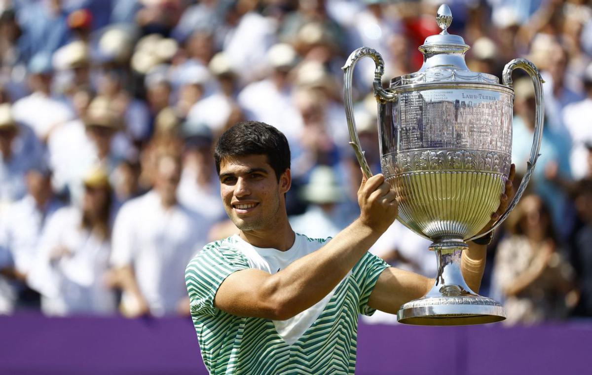 Carlos Alcaraz levanta el trofeo conquistado en Queen’s. | PETER CZIBORRA/REUTERS