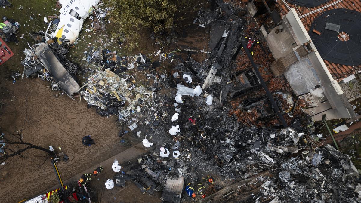 Fotografía aérea que muestra agentes de policía científica de Brasil trabajando en los restos del fuselaje del avión de la aerolínea Voepass que se estrelló el 9 de agosto de 2024 en la ciudad de Vinhedo (Brasil) con 62 personas a bordo.