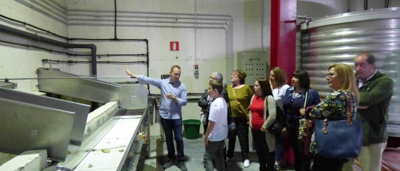 Hugo Piquero enseña al grupo cómo se realiza el proceso de selección de manzana en el llagar Viuda de Corsino.